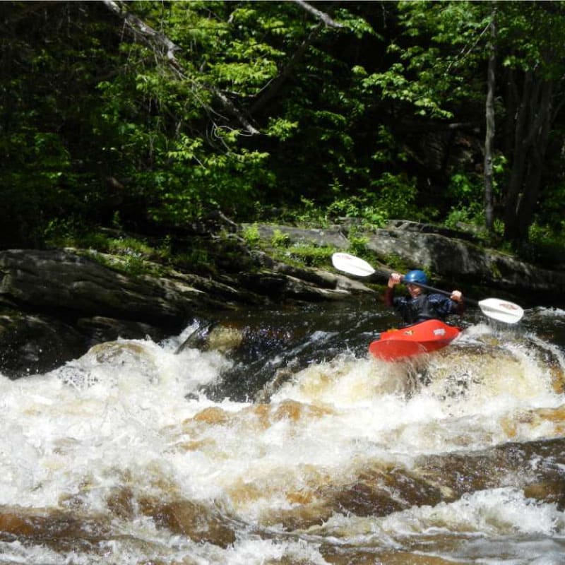 Kayaker running rapids