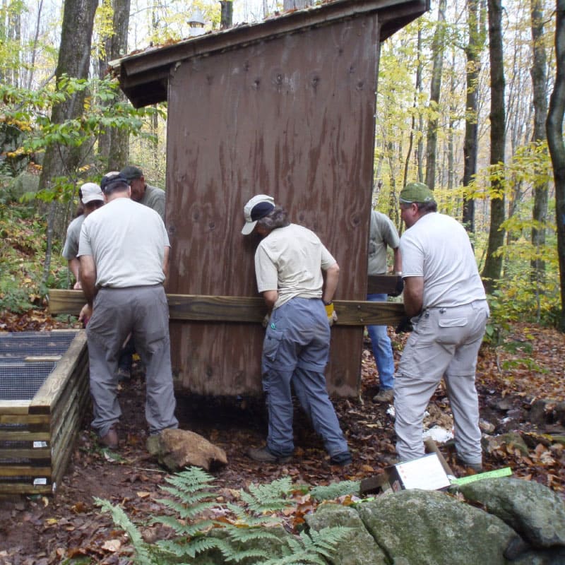 Workers shift a privy