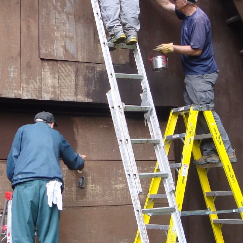 Workers painting a tool shed