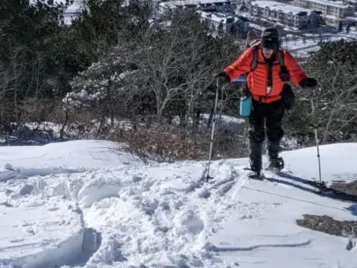 Back cover: Man snowshoeing on a hill overlooking a city