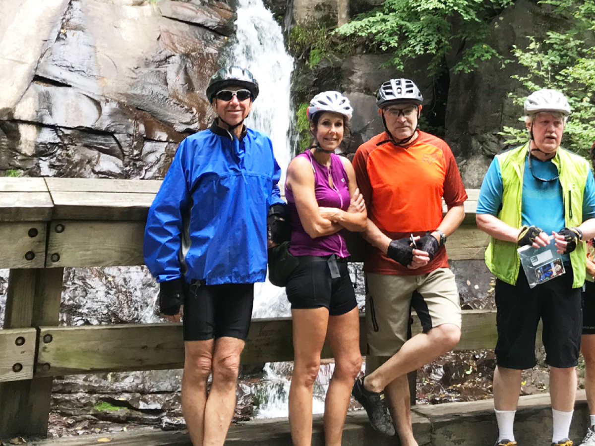 Back cover: Cyclists pose in front of a waterfall