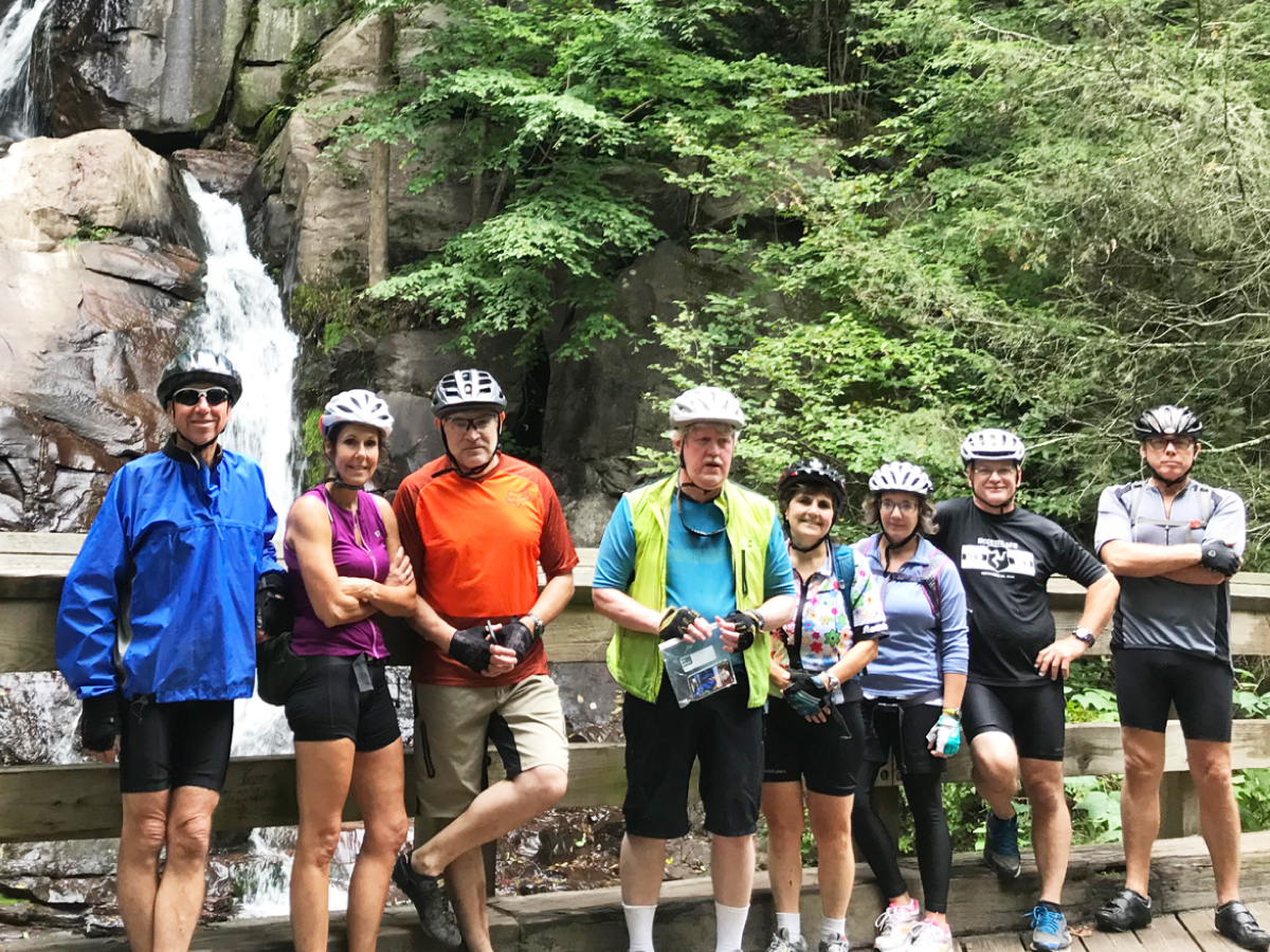Front cover: Cyclists pose in front of a waterfall