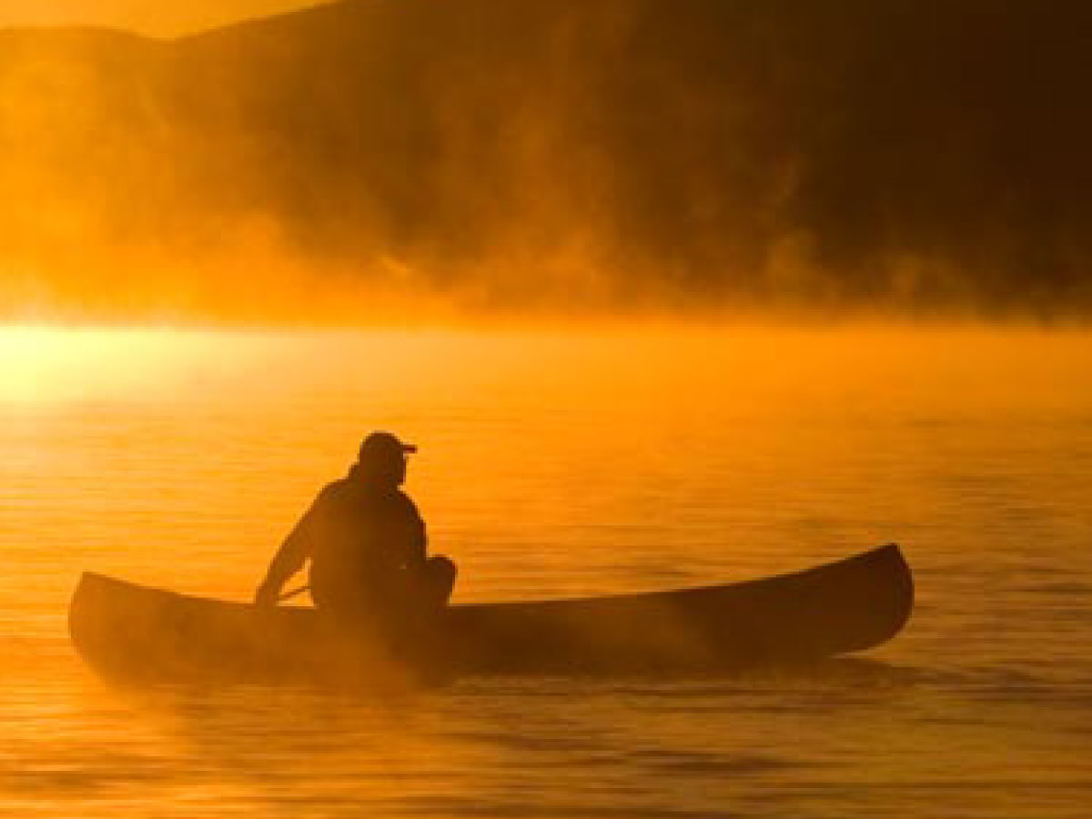 Canoeist paddling at sunset