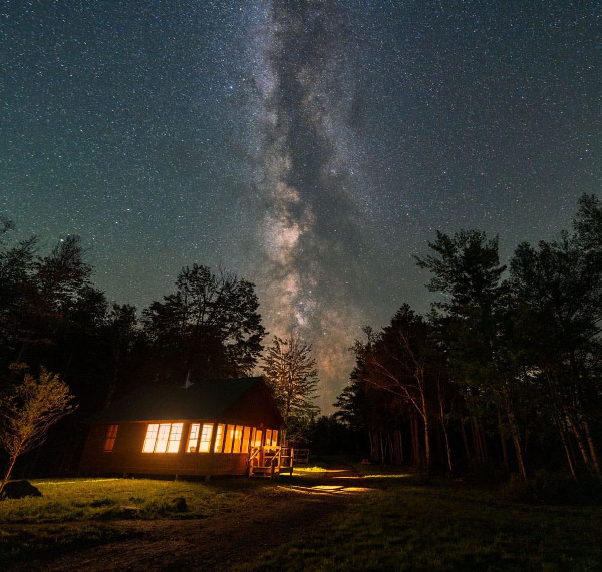 Starry night sky over a cabin