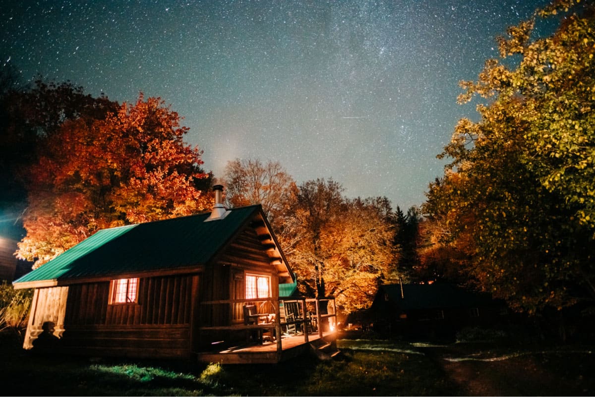 Starry night sky over a cabin