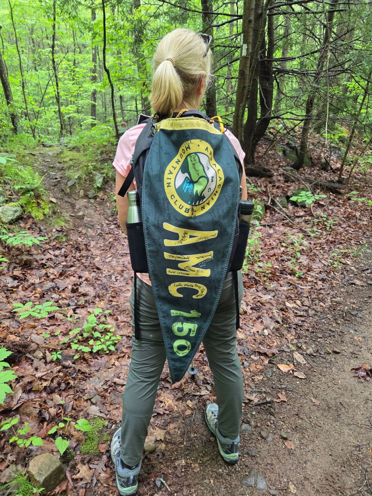 Hiker with the AMC 150 Relay banner
