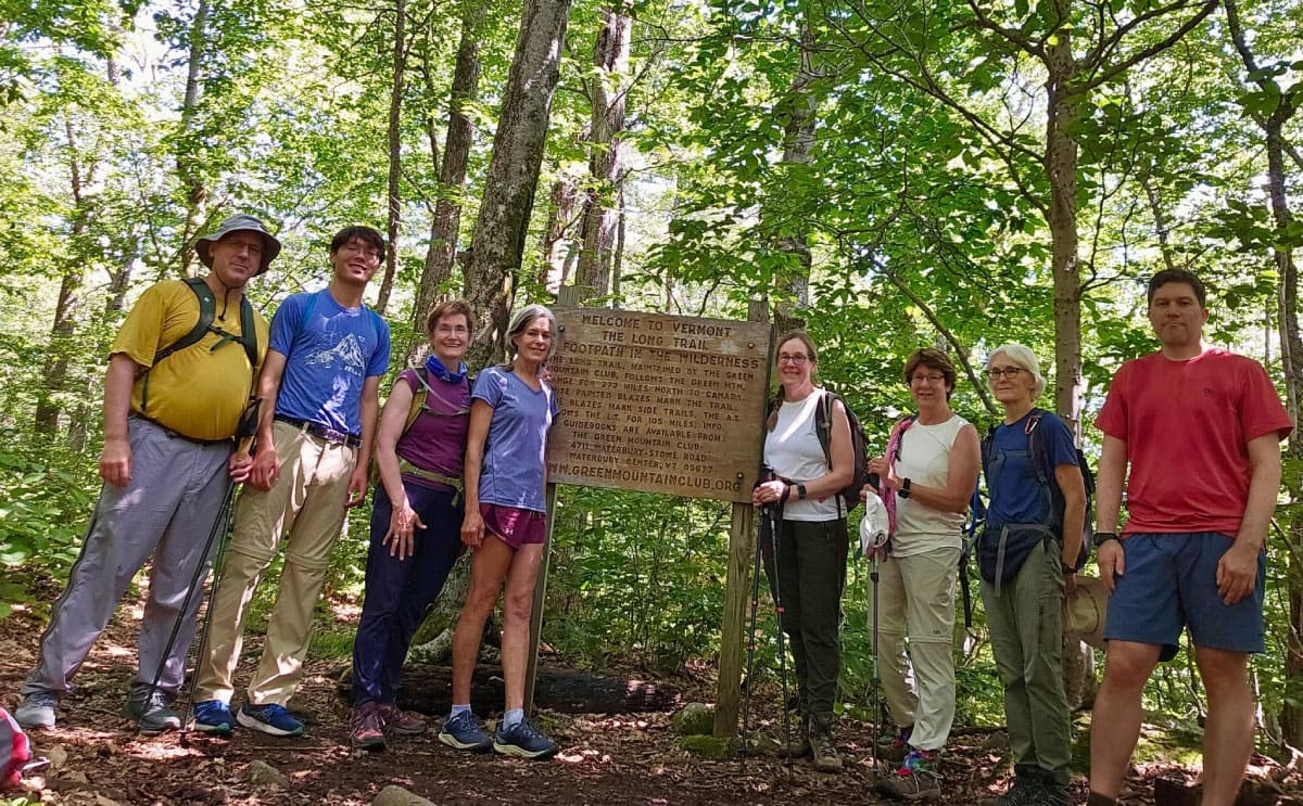 Hikers standing by a trail sign