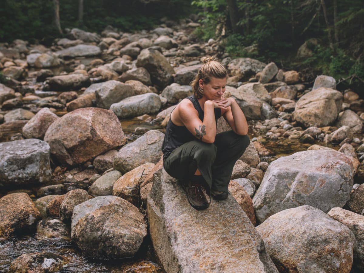 Woman sitting by a river