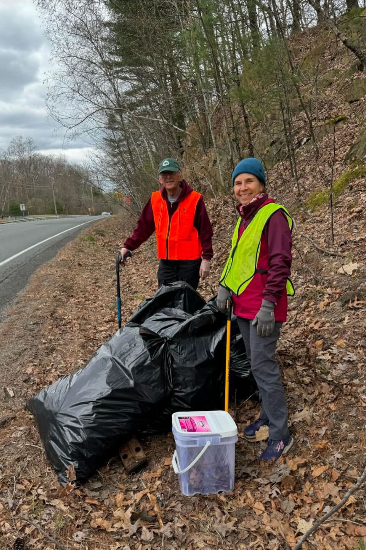 Workers standing near bags of trash