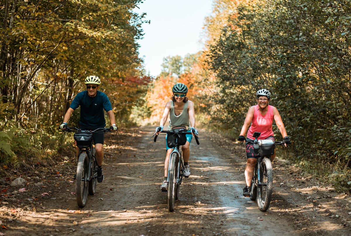 Three people biking on a gravel road