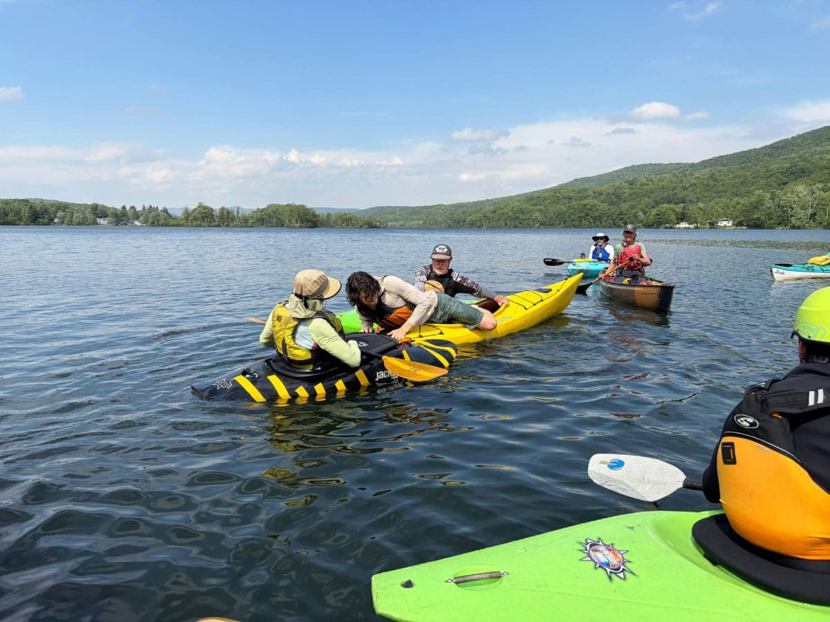 Kayakers learning how to get back in their boats after a spill