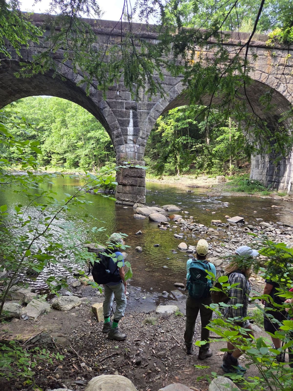 Hikers viewing stone railway arches