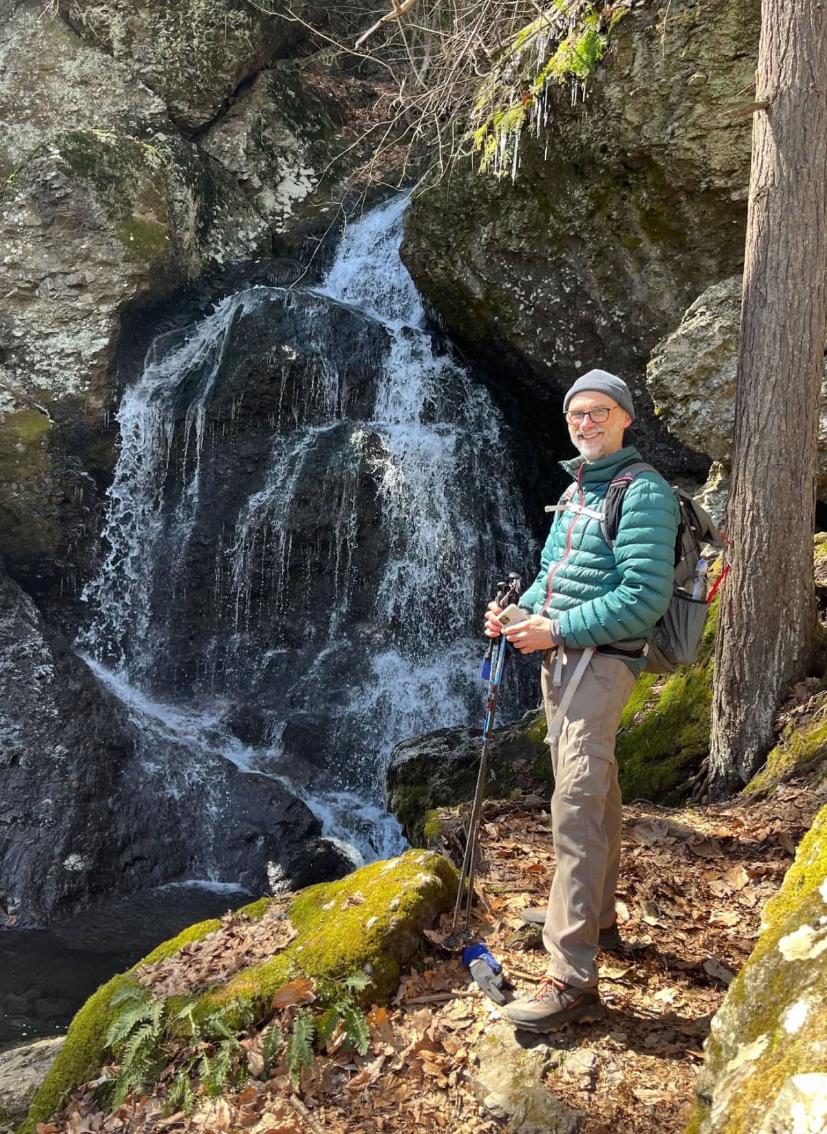 Hiker standing beside a waterfall