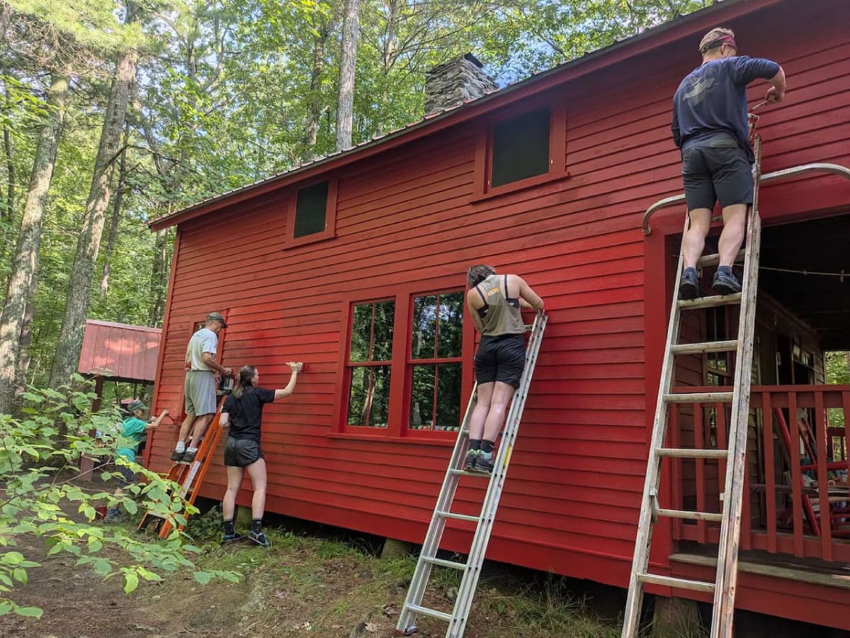 People painting a cabin