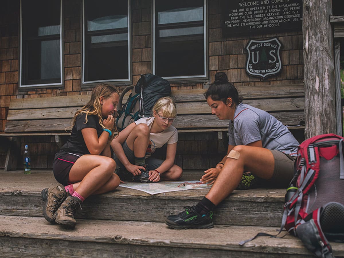 A mom and two kids examining a map