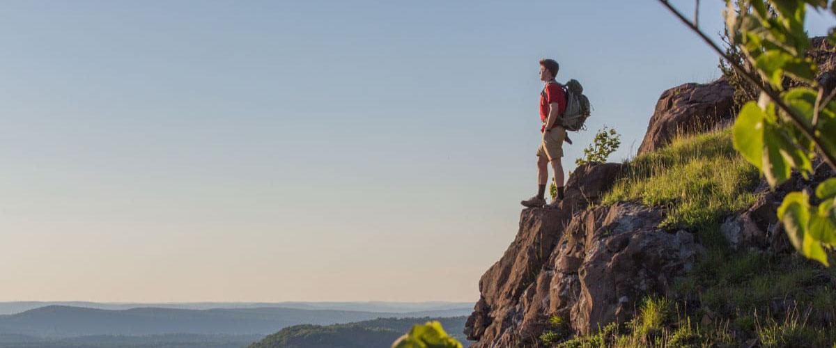 A hiker views the surrounding valley