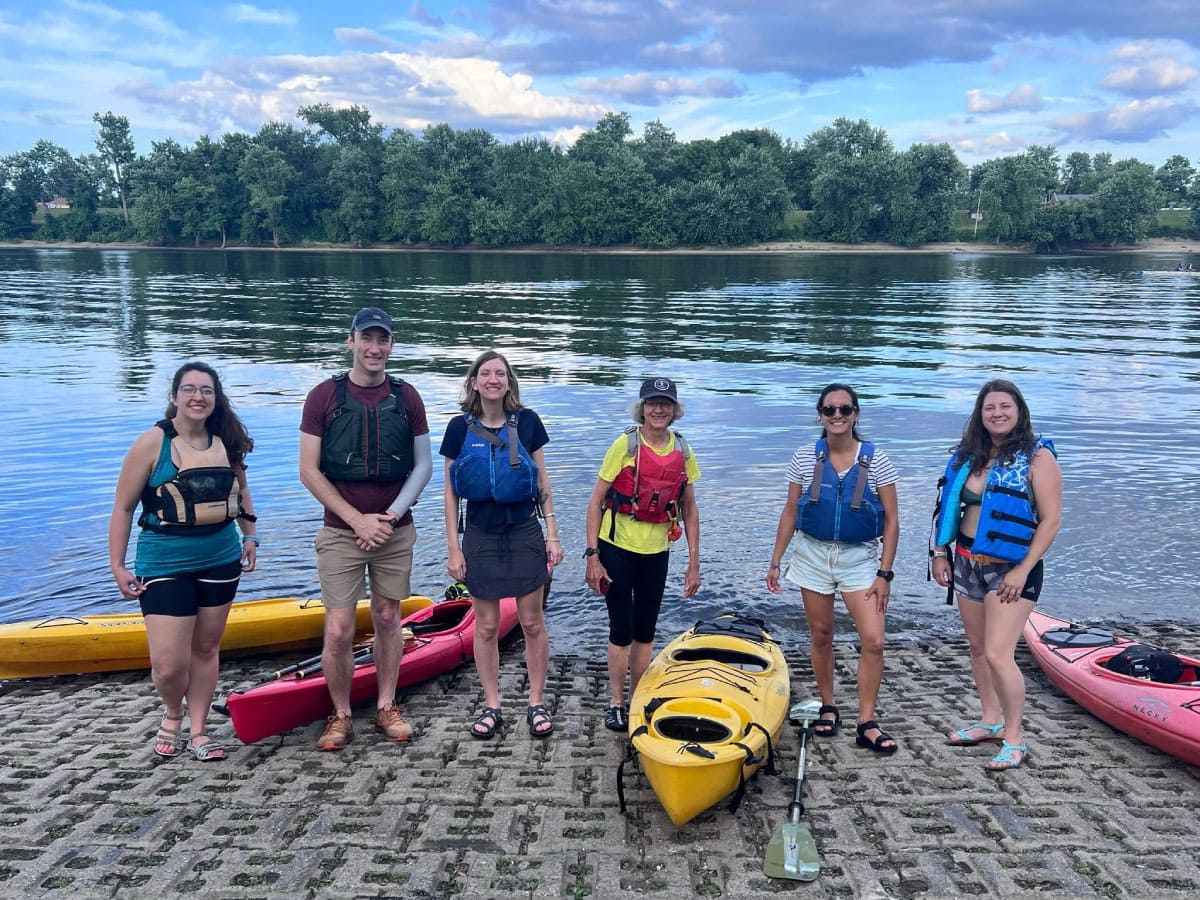Kayakers standing beside their boats