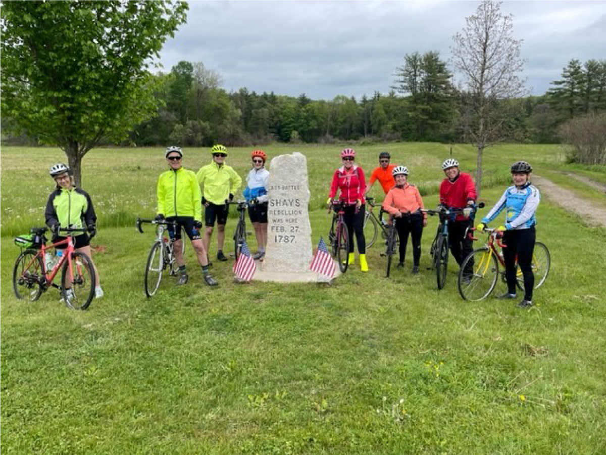 Cyclists pose for a photo at Shays Rebellion monument