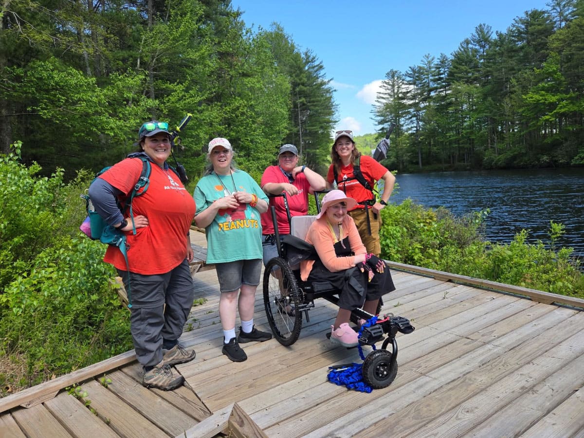 Wheelchair hiker and friends stop for a photo op on a deck 