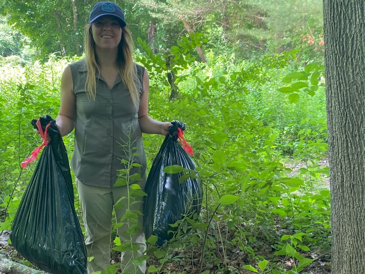 A woman displays bags of garlic mustard