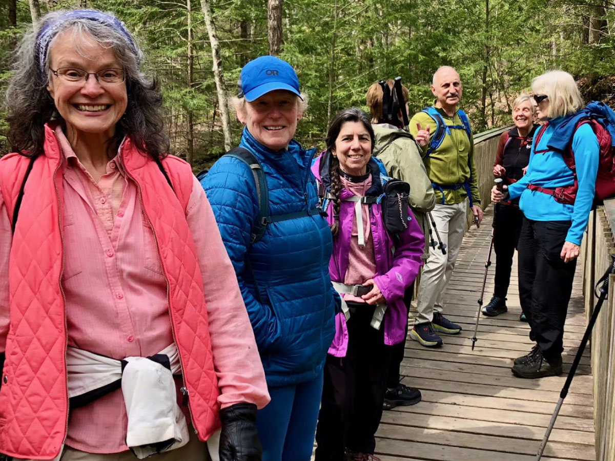 Hikers on a bridge over the Mill River