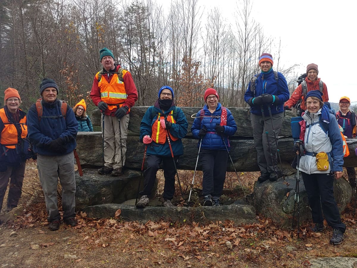 Hikers stop for a photo op on a rock