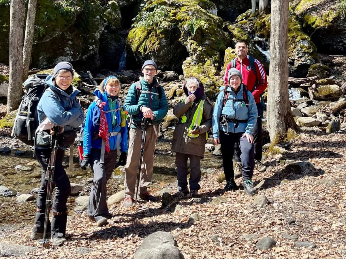 Group photo of hikers near a brook