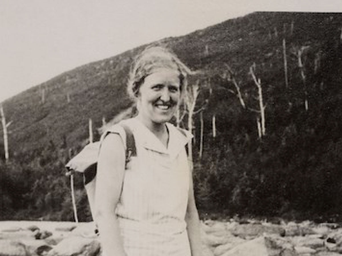 A hiker standing on rocks at the edge of a pond