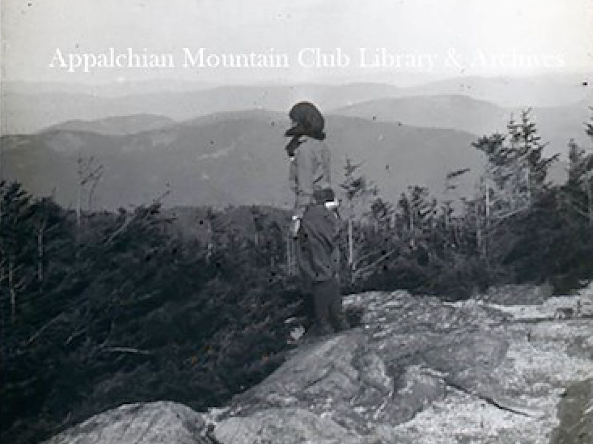 A hiker looks east from the summit of Speckled Mountain